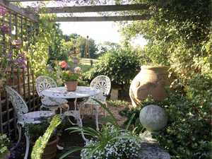 english garden with terracotta pots and furniture