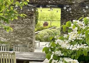 wooden garden furniture with planter in distance